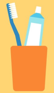 A soft-bristled toothbrush and tube of toothpaste in an orange cup against a yellow background to prevent periodontal disease