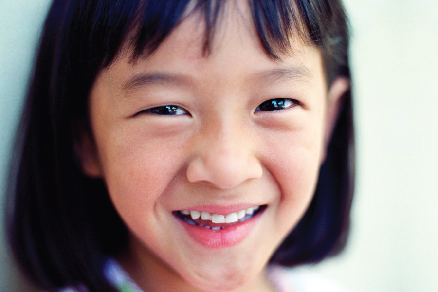 Closeup of a little Asian girl smiling in Forest Hill, TX, after her visit to the dentist